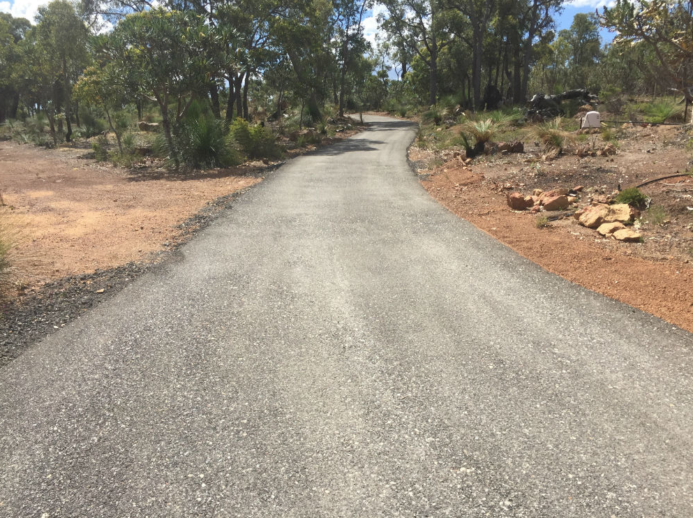 This is a photo of a hot spray & seal bitumen driveway which is in the process of being installed by Yatala Surfacing Solutions