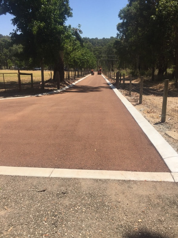 This is a photo of a hot spray & seal bitumen roadway which is in the process of being installed by Yatala Surfacing Solutions